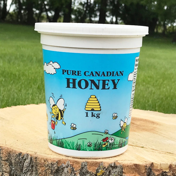 picture of a container of pure Canadian honey on a log