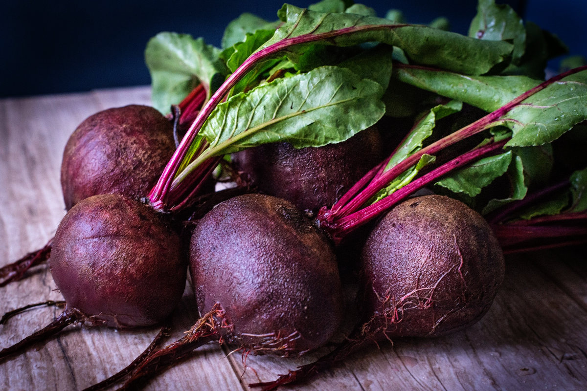 a bunch of beets with tops on boards