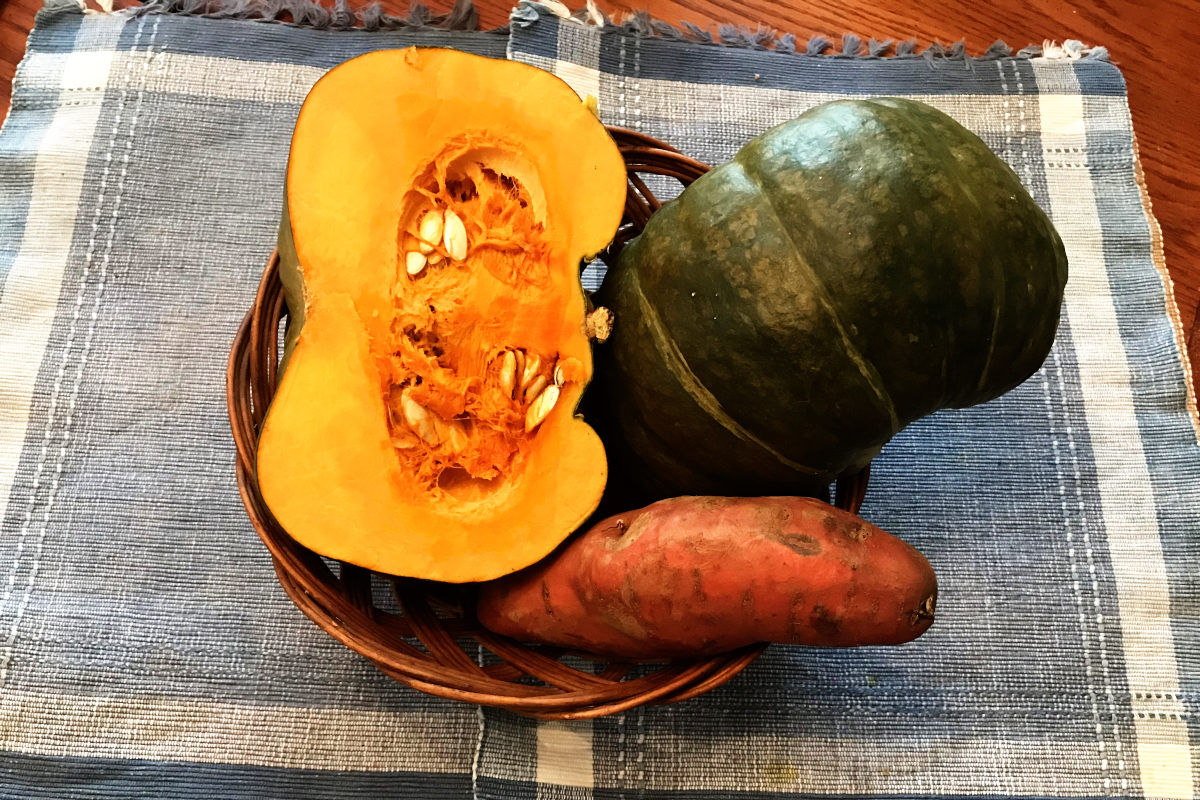 buttercup squash and sweet potato in a basket on a placemat