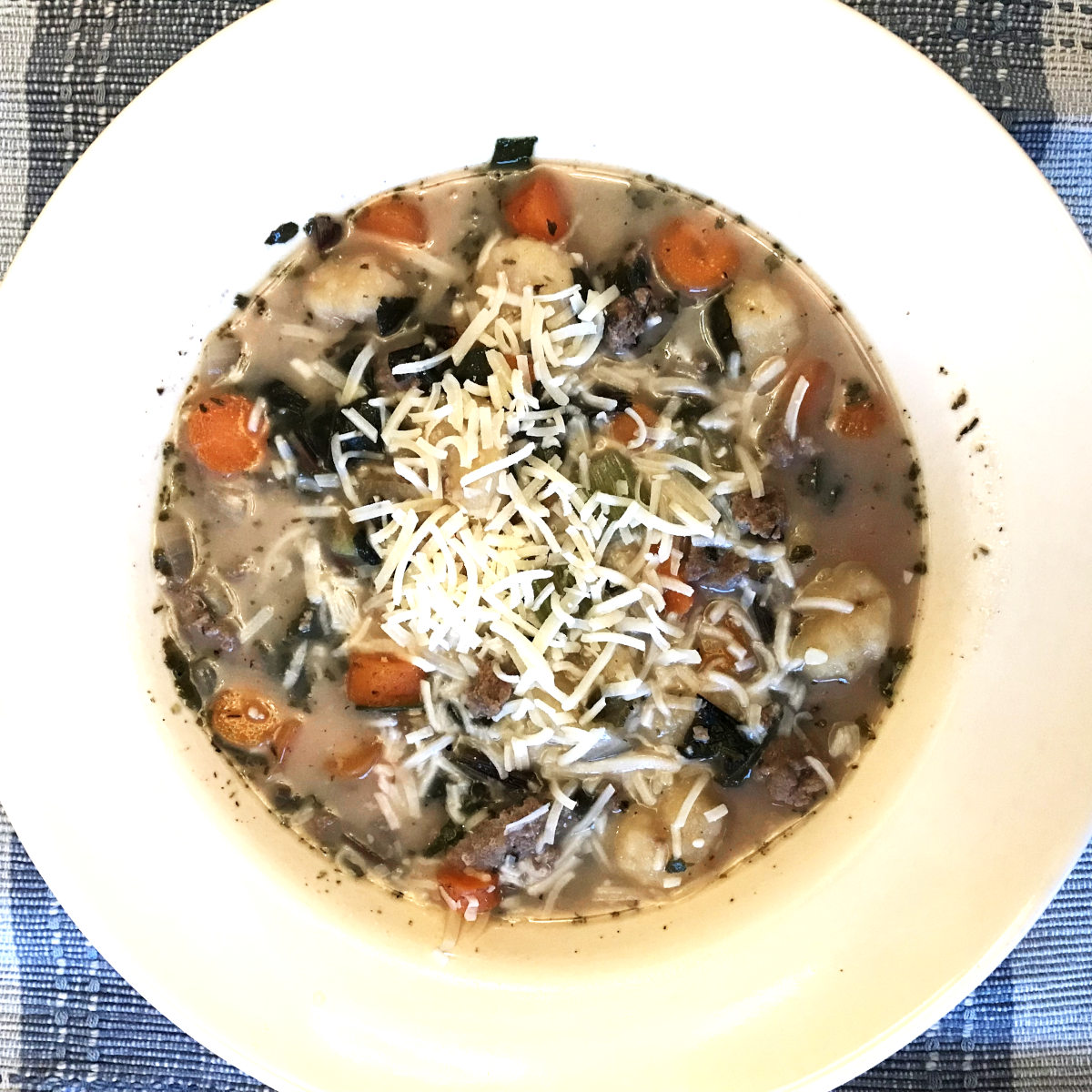 gnocchi soup with Parmasan garnish in bowl