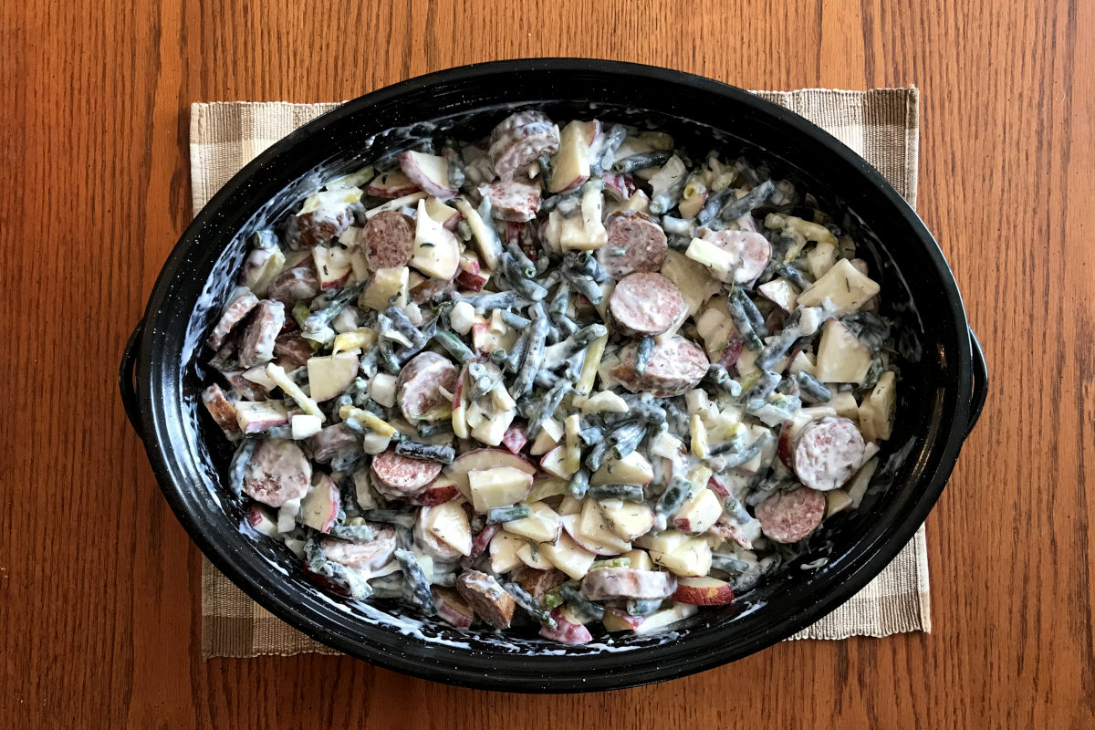 green bean casserole in black enamel casserole dish ready to go into the oven