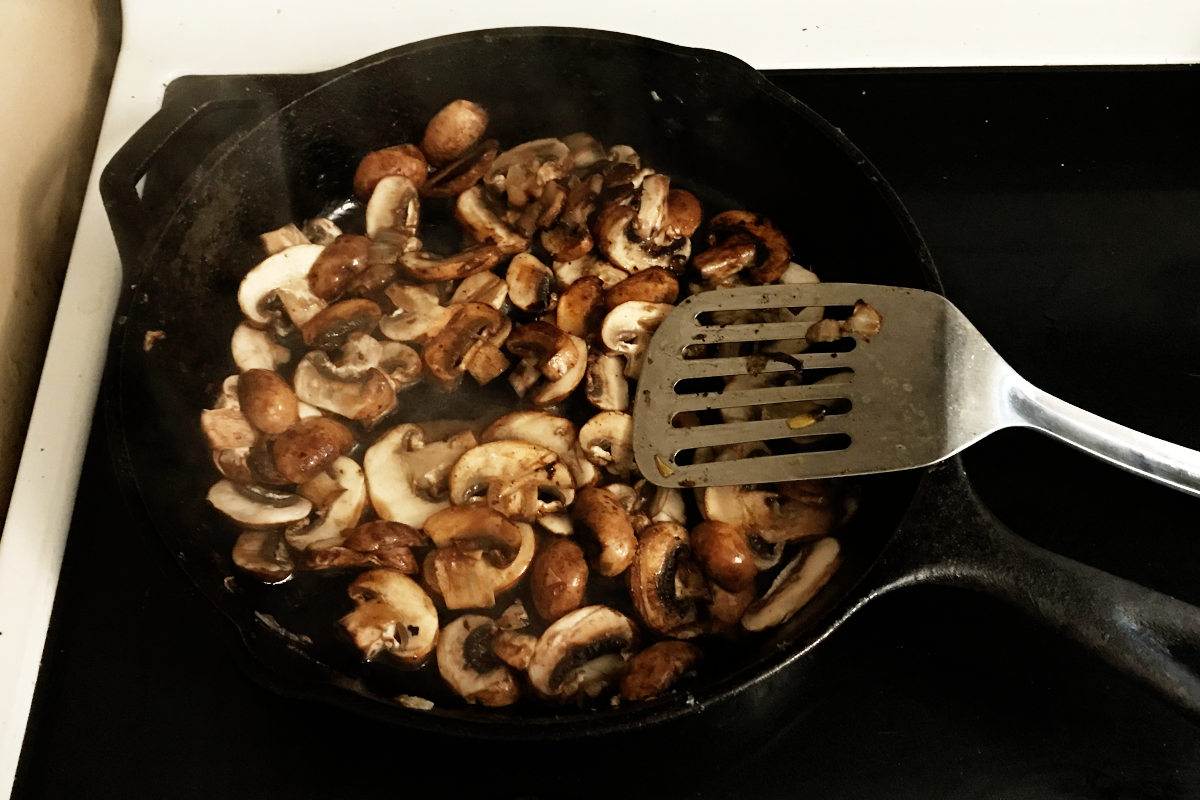 mushrooms frying in cast iron pan