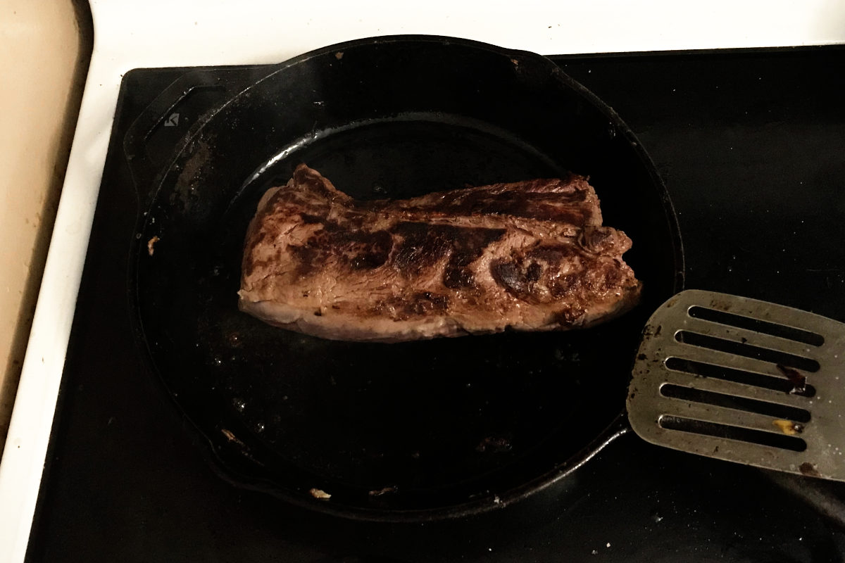 venison roast searing in cast iron pan