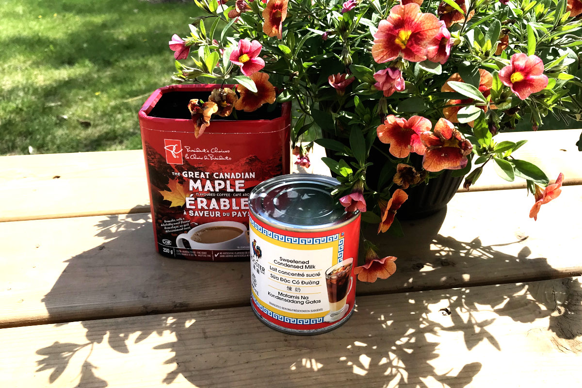 Container of Great Canadian Maple flavoured coffee, can of sweetened condensed milk and potted flowers