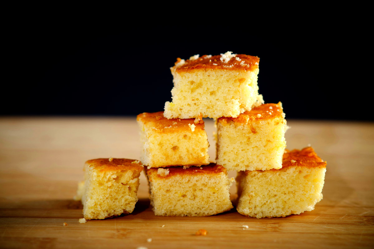 pieces of johnny cake cornbread stacked on a wooden cutting board