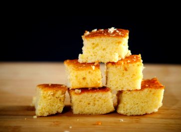Johnny Cake Cornbread stacked on a wooden cutting board