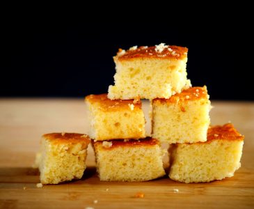 Johnny Cake Cornbread stacked on a wooden cutting board