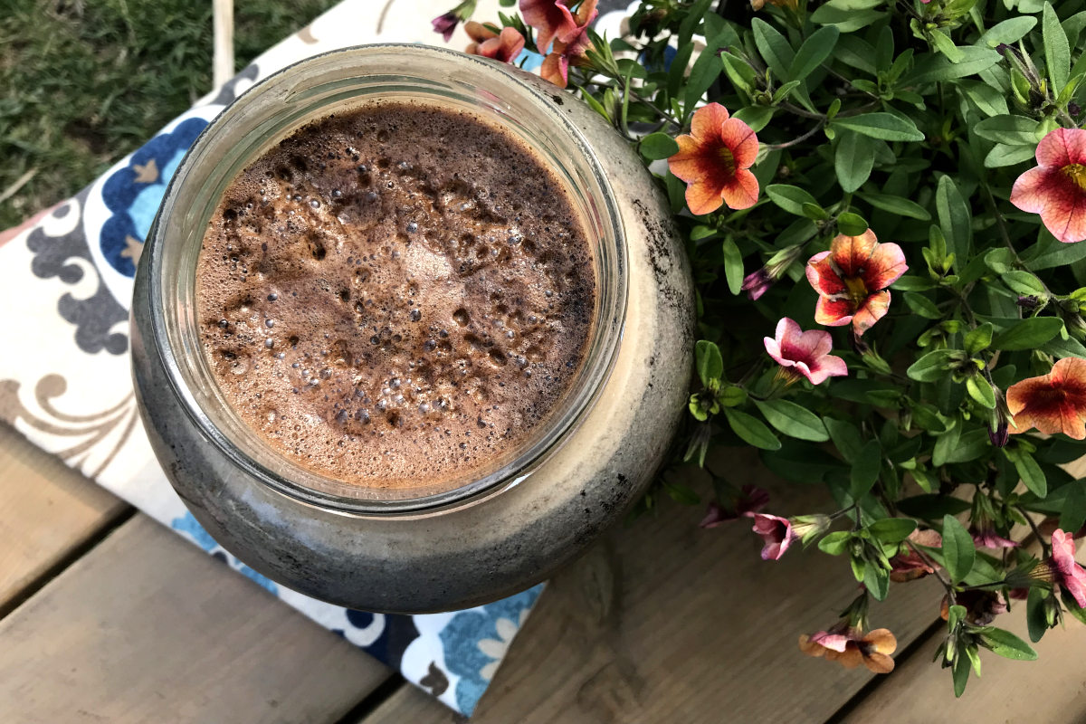 Top view of jar of cold brew coffee and potted flowers