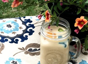 mug of iced coffee and potted flowers