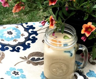 mug of iced coffee and potted flowers