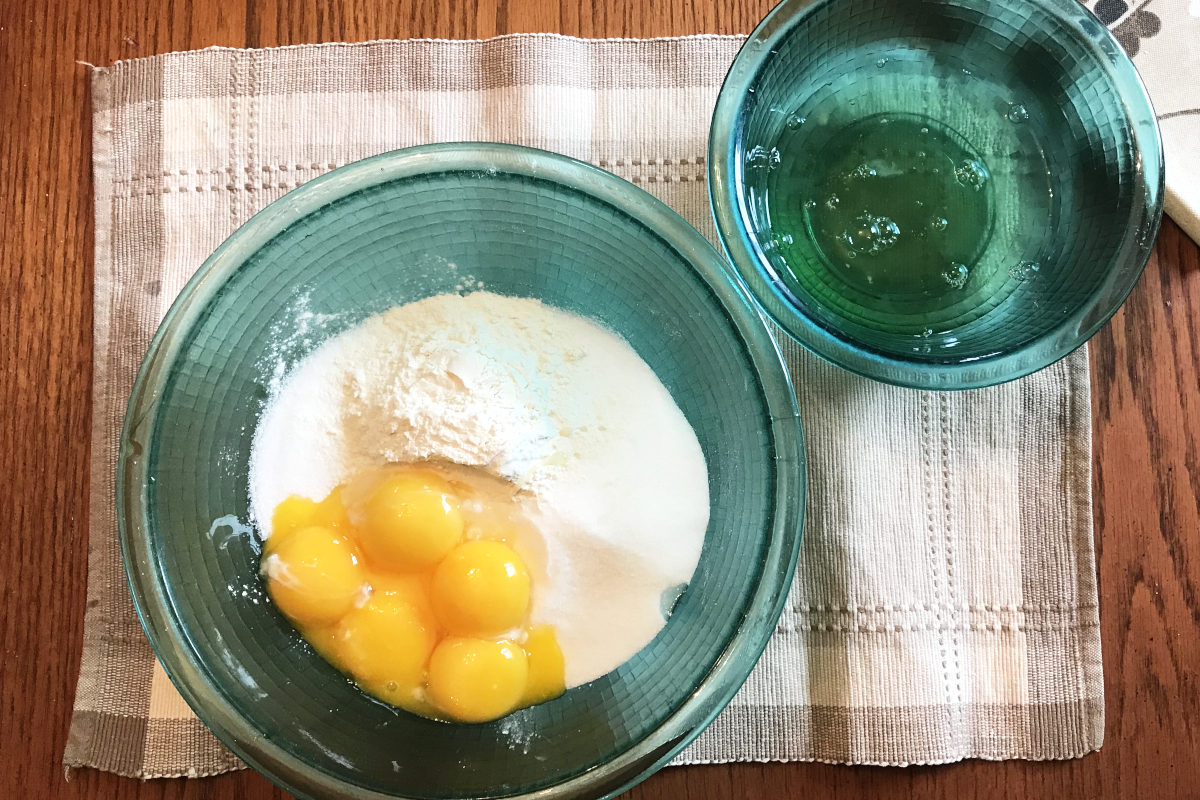 bowl of custard ingredients with egg yolks and bowl of egg whites
