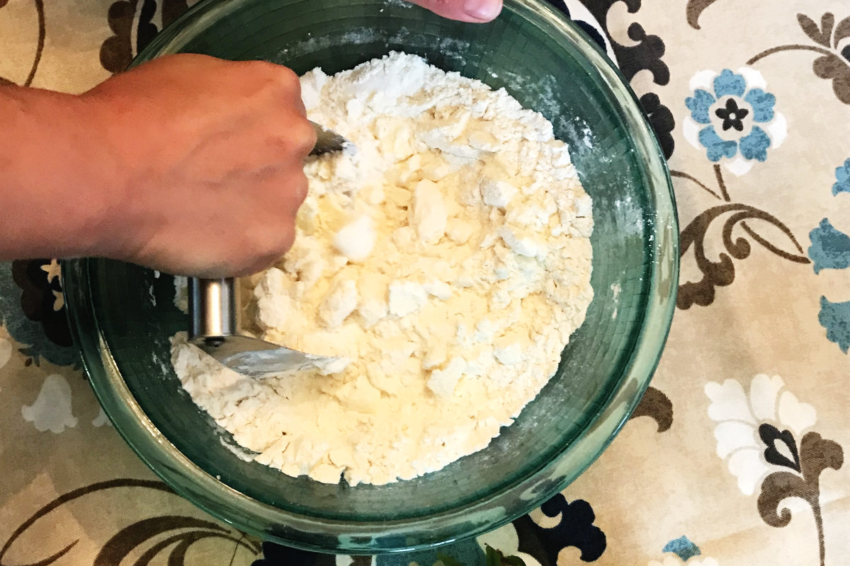 cutting butter into rhubarb dessert base with pastry cutter.