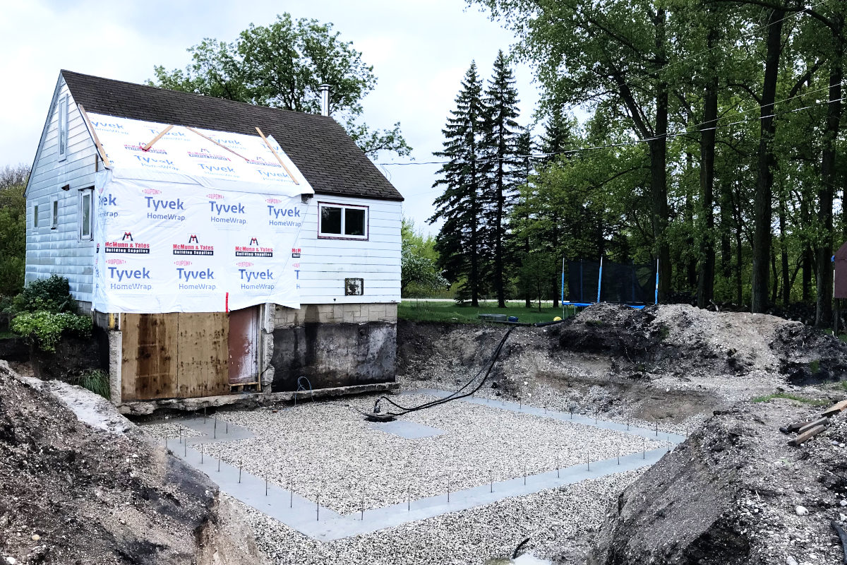 Drain stone laid in and around the concrete foundation footings of our old house remodel addition