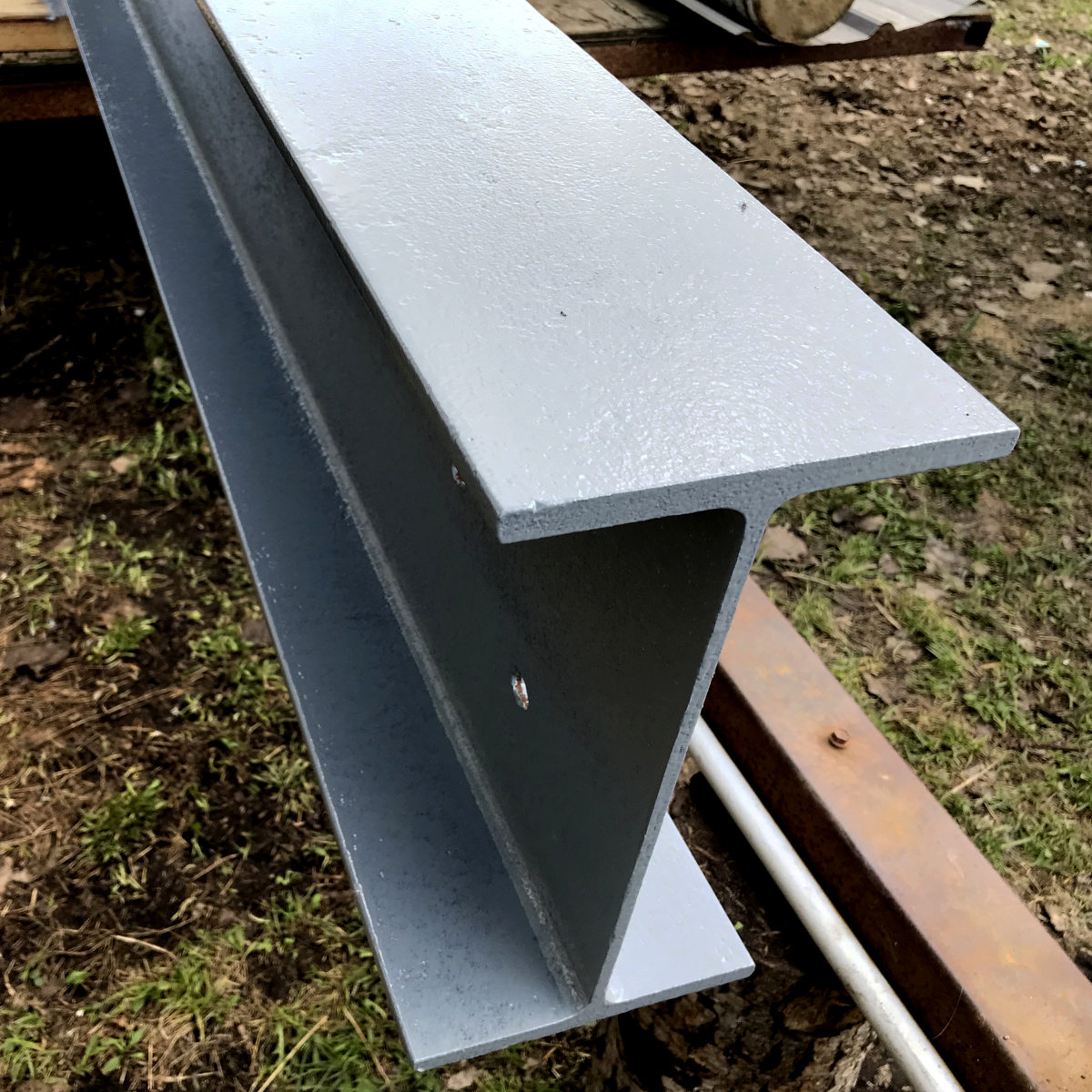 steel beam close-up painted with glossy grey enamel for our old house remodel