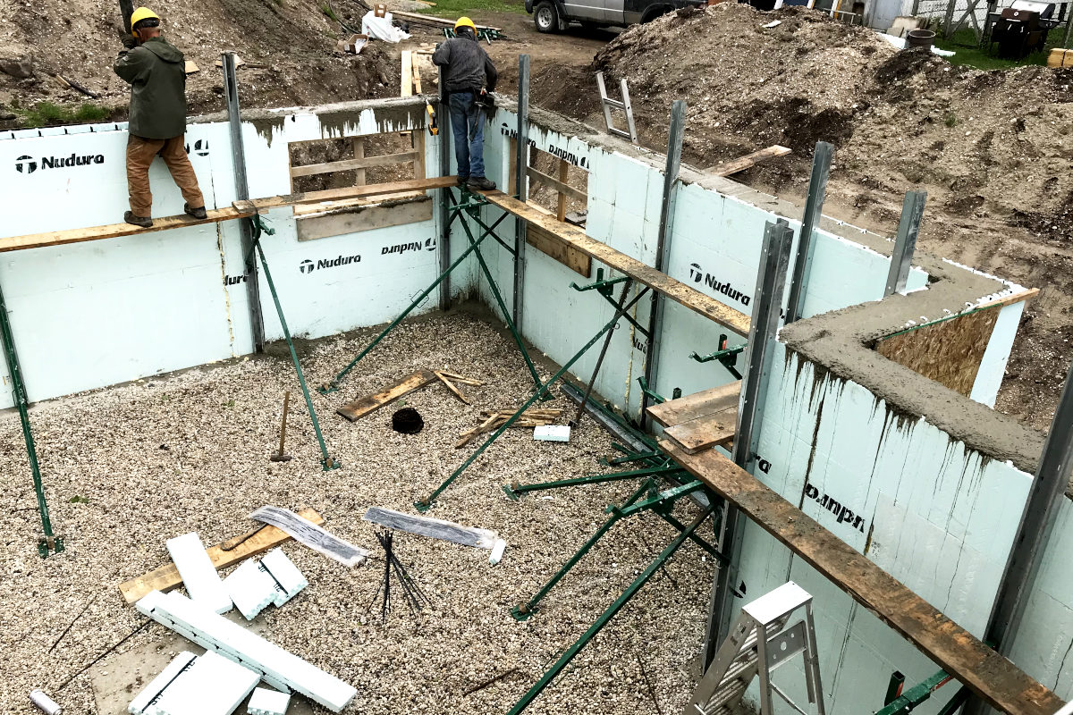 Cement being pumped into the basement wall forms for the addition on our old house remodel
