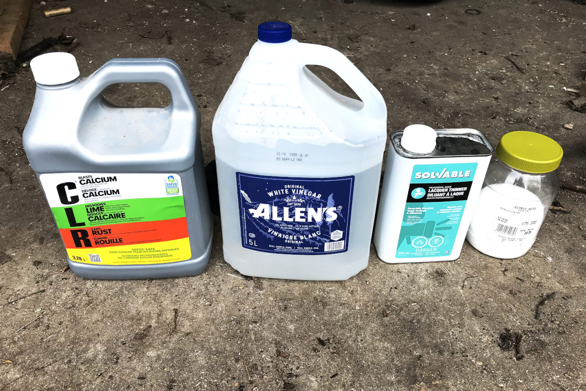 Bottles of C.L.R., white vinegar, lacquer thinner and citric acid for removing rust from the beam in our old house remodel