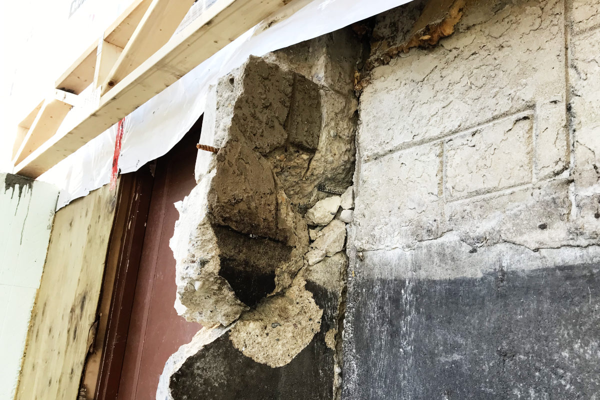 cracked concrete wall sticking out of the old basement in the old house remodel