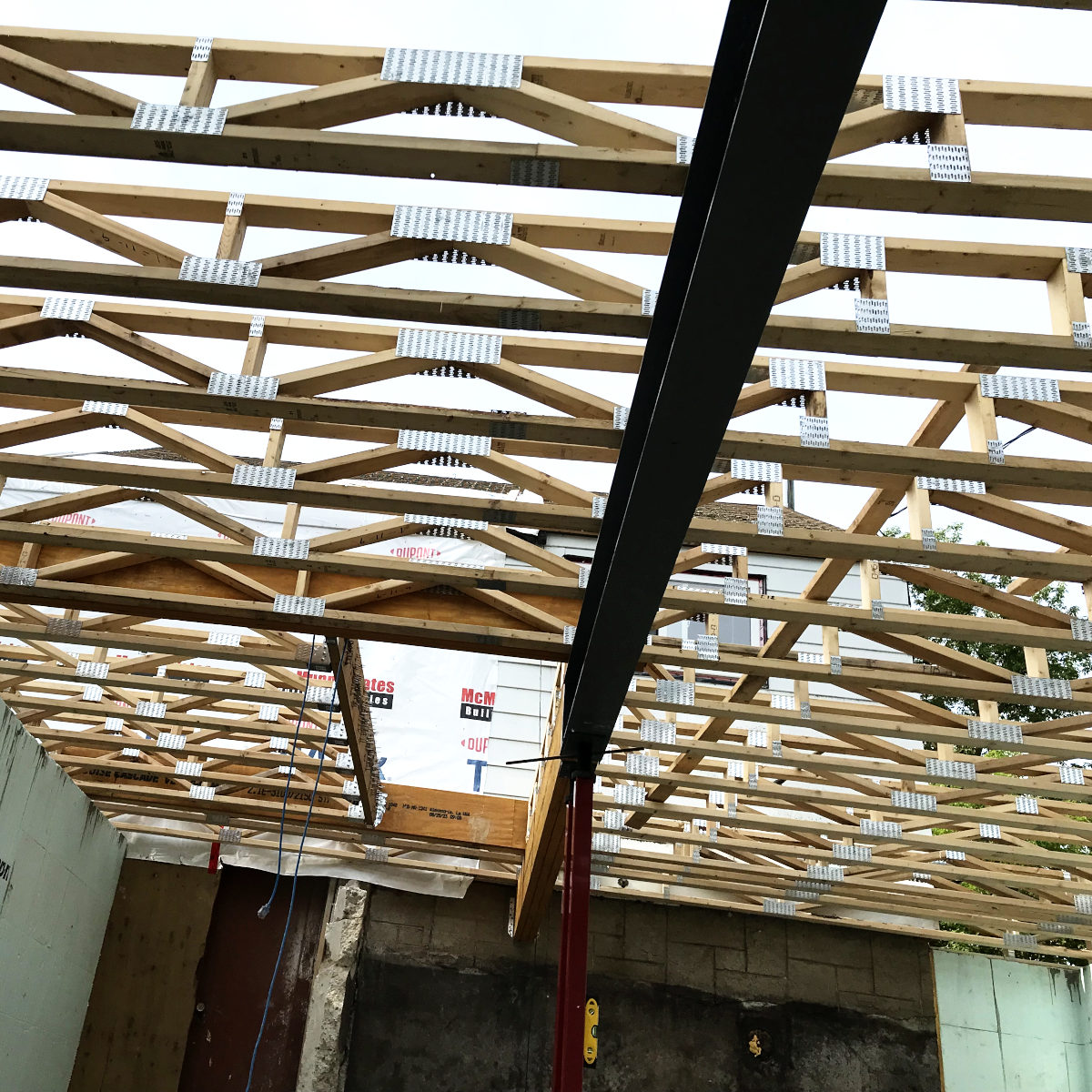 view from below of floor joists, wood and steel beams, the stair opening in old house remodel