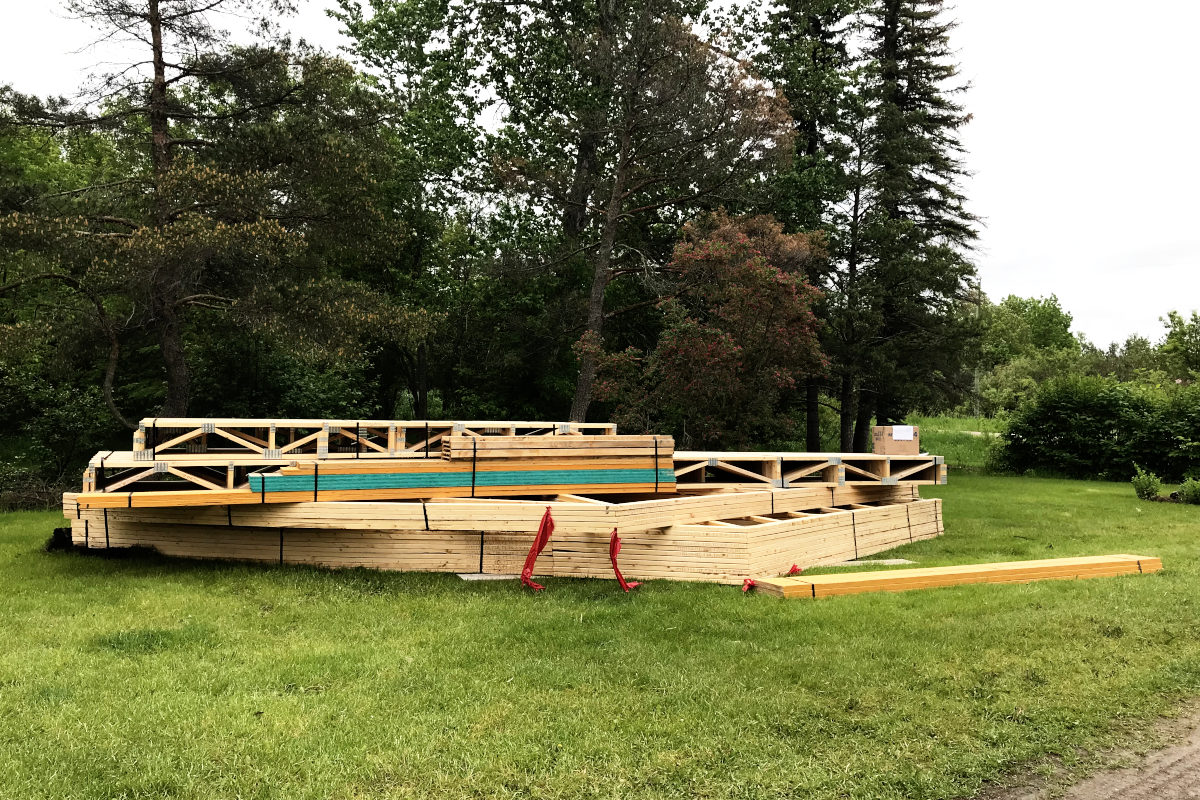 truss and floor joist delivery for the old house remodel addition sitting on the lawn 