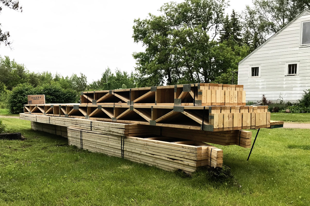 View of the underside of the trusses for the old house remodel sitting on the lawn.
