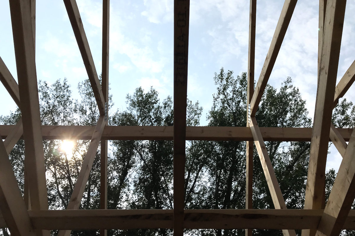 Close up of sky through the roof trusses of the addition for the old house remodel