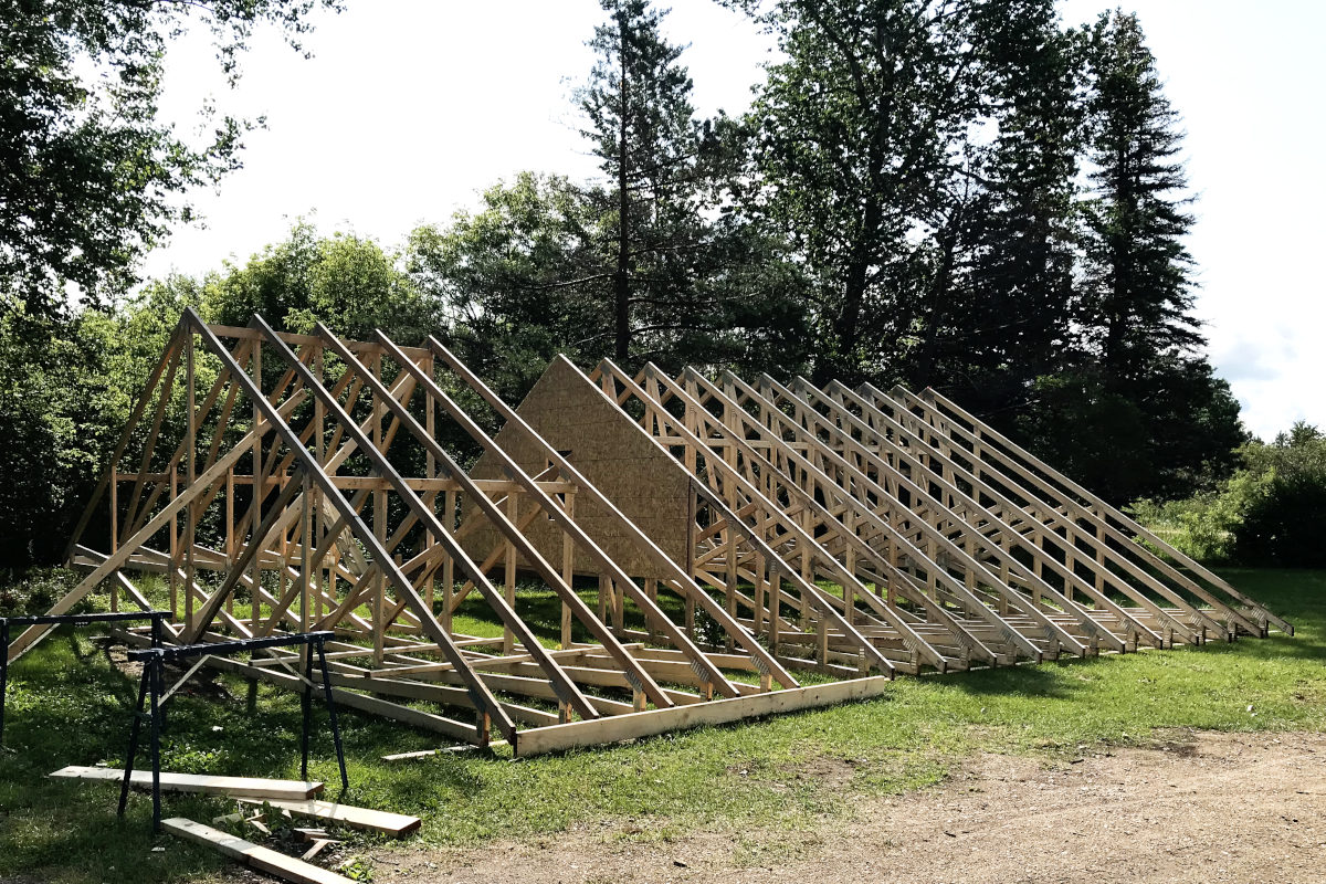 Roof trusses set up and tied together on the ground in two sections for the addition of the old house remodel.