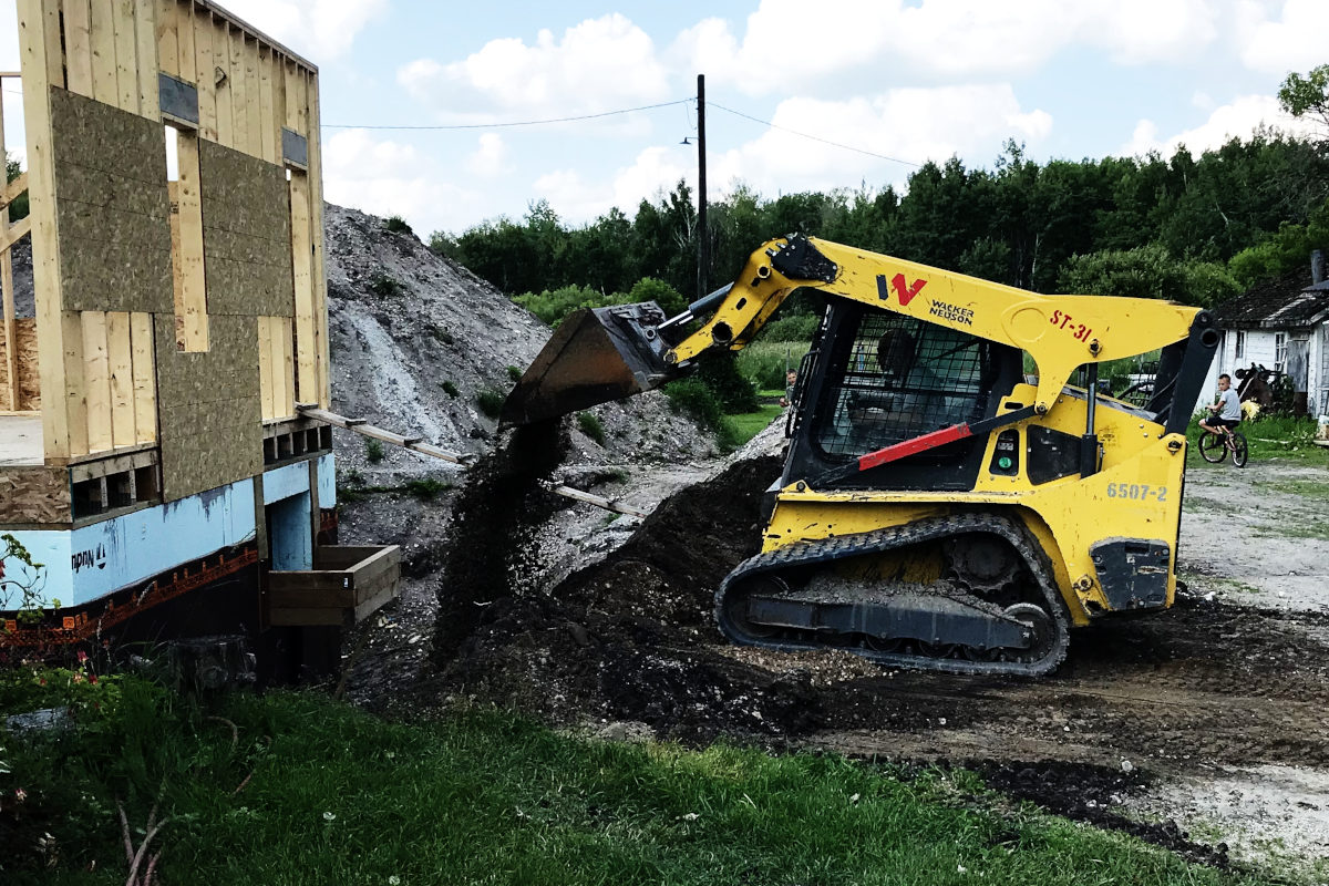 skid steer back filling the basement of the addition for the old house remodel