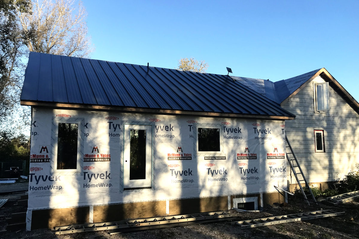 exterior of old house remodel with windows and house wrap installed
