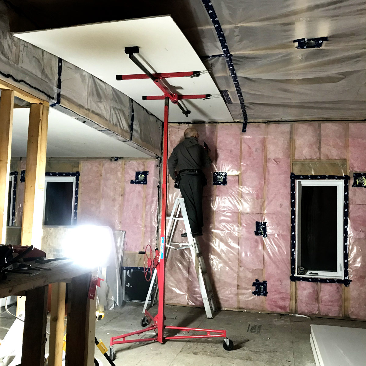 installing drywall on ceiling with an mechanical lift.