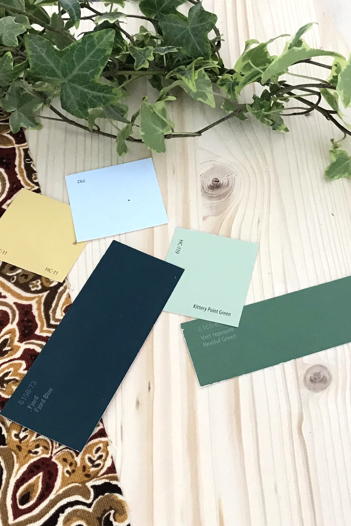 paint chips on pine with deep red and gold fabric, and an ivy plant