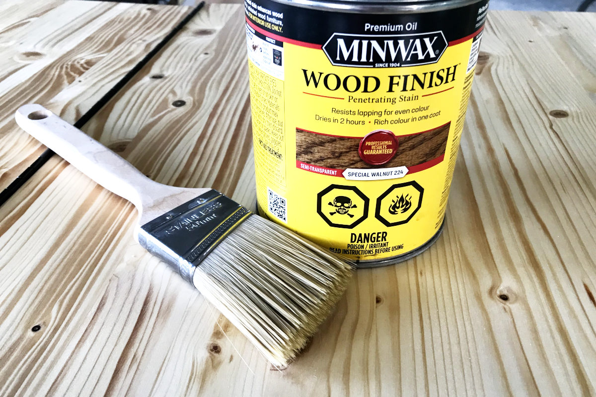 a can of Minwax special walnut stain with paint brush sitting on wood