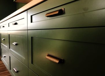 green kitchen drawers with copper pulls
