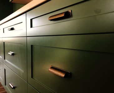 green kitchen drawers with copper pulls