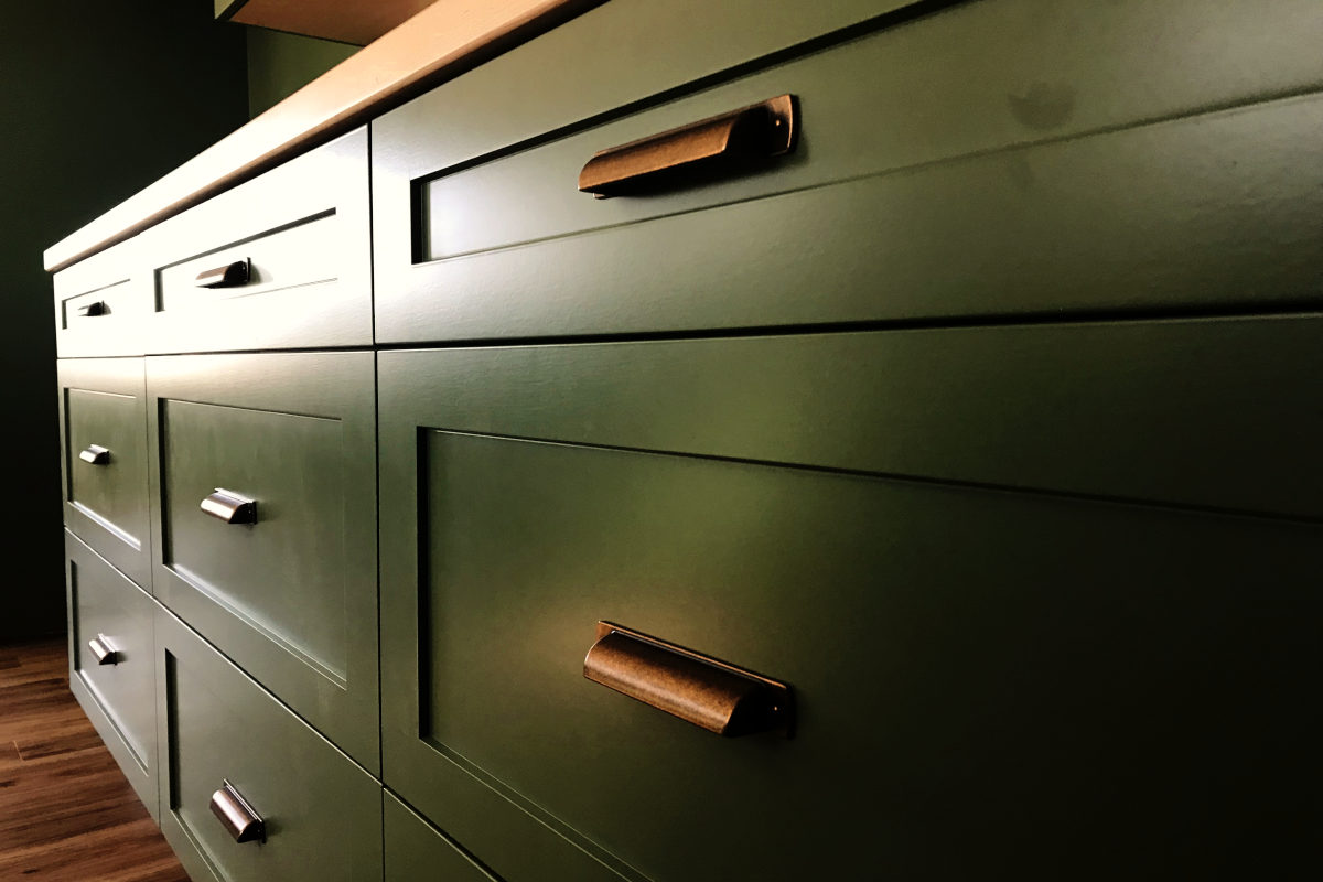 green kitchen drawers with copper pulls