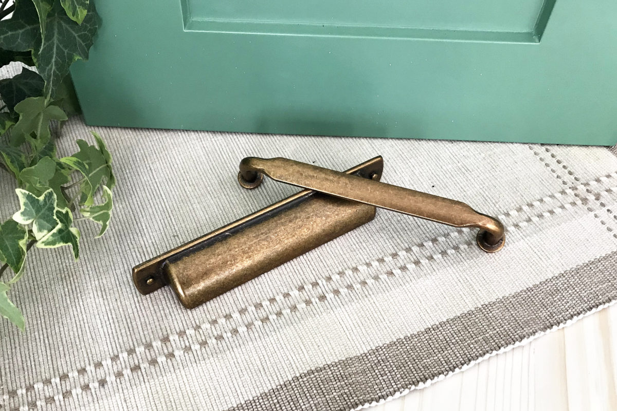 Sico's Restful Green cabinet door, old brass looking handles, butcher block, with ivy and placemat