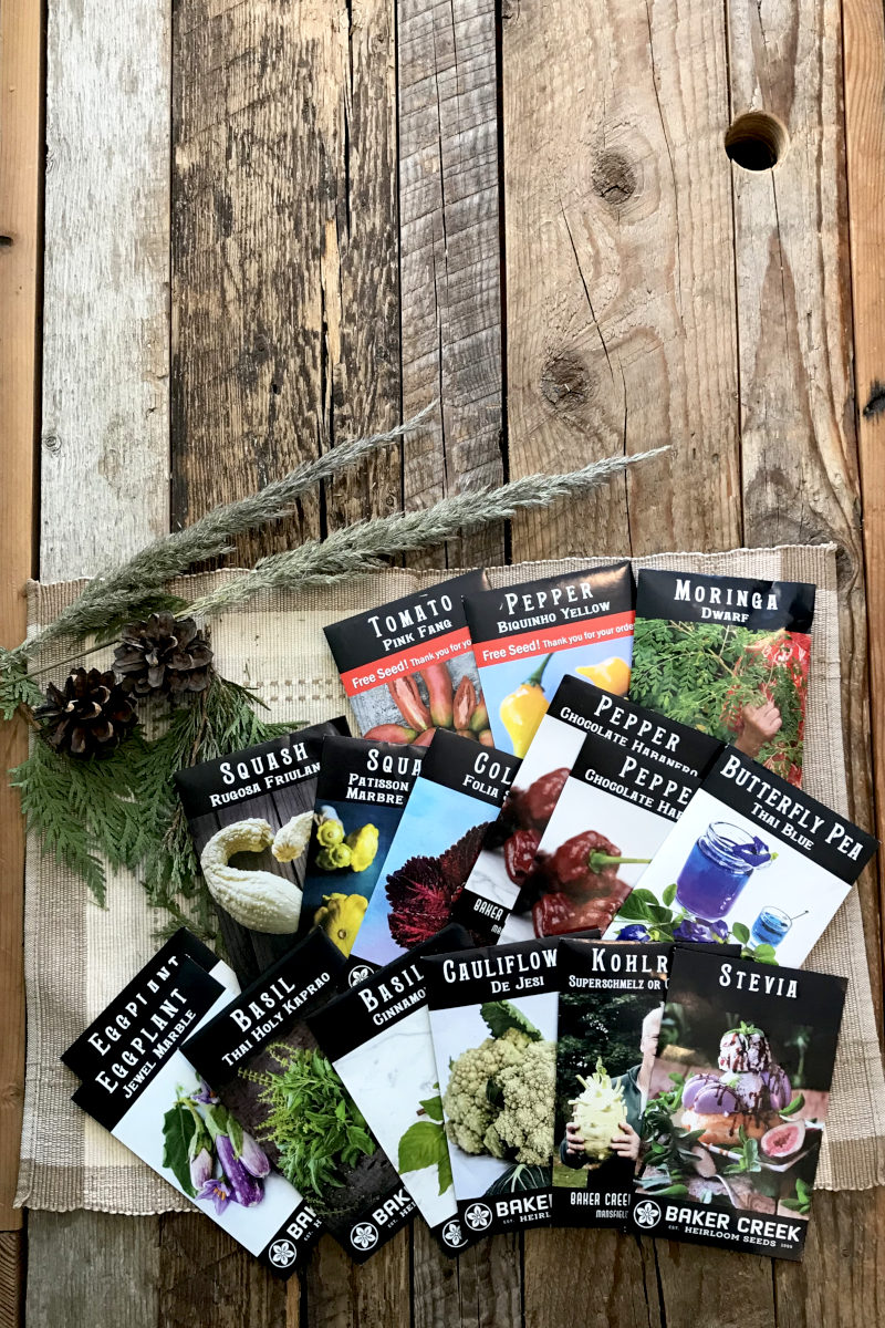 Fifteen seed packs from Baker Creek displayed on weathered wood planks