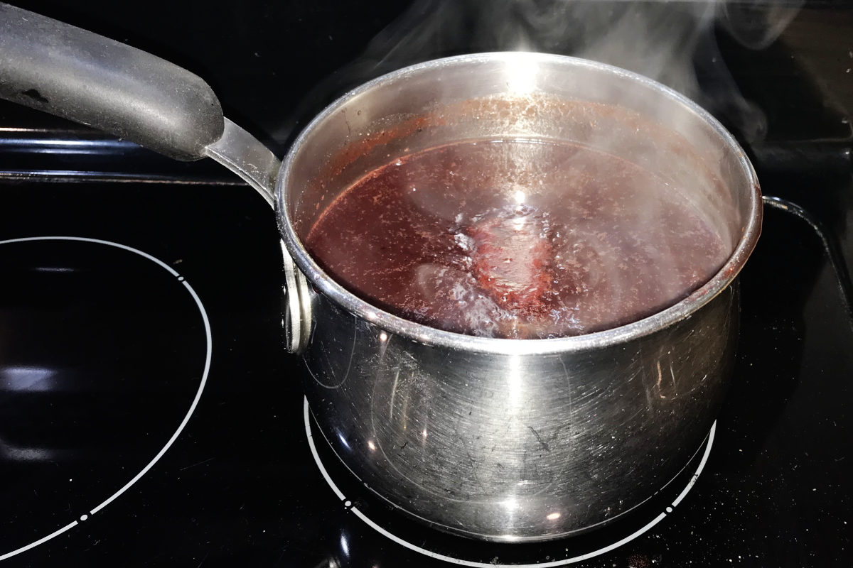 steaming saucepan of chokecherry BBQ sauce on the stove.