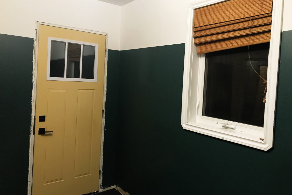 painted mudroom with Fjord Blue 3/4 up the walls, white remaining. View of yellow exterior door and window.