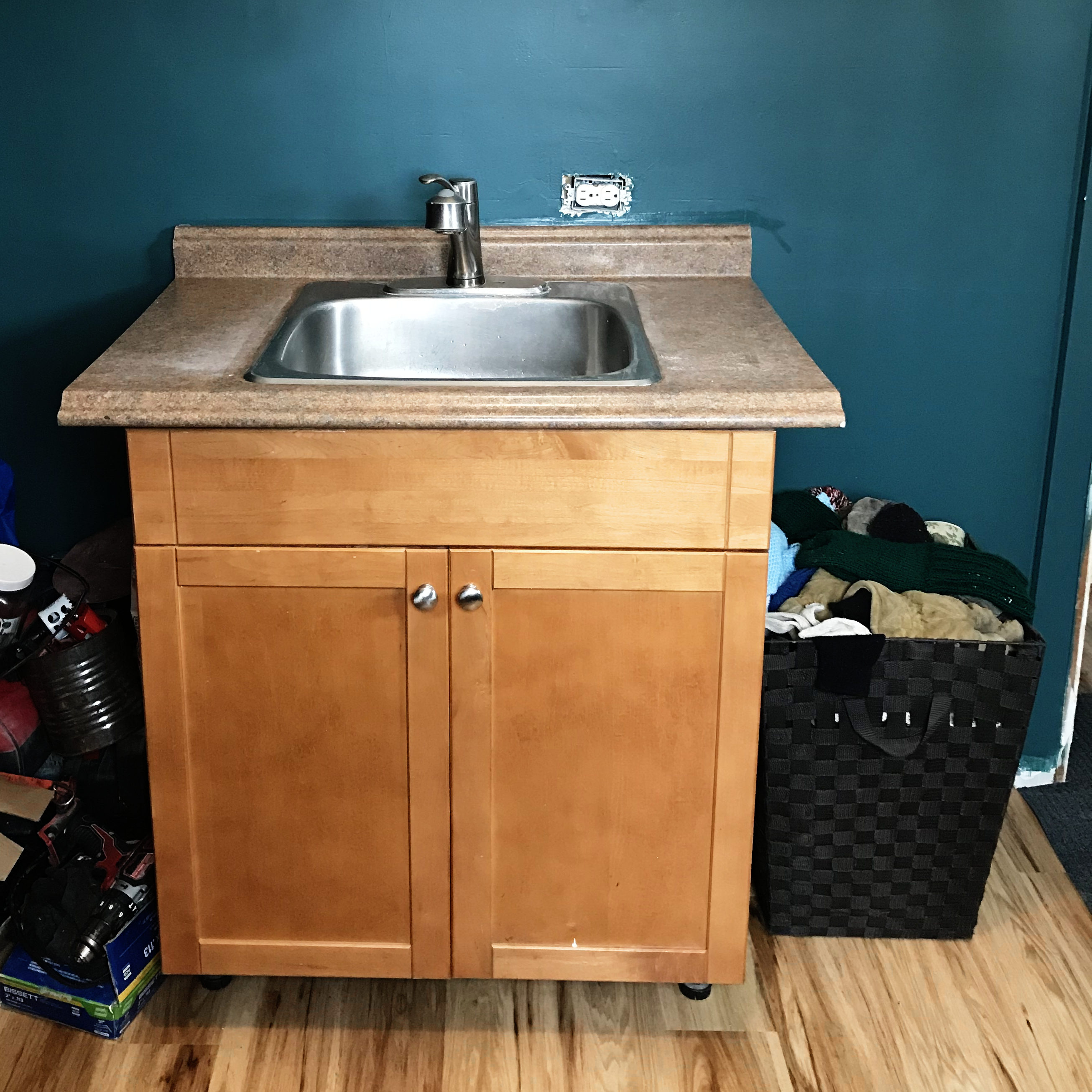 close up view of sink cabinet in painted mudroom.