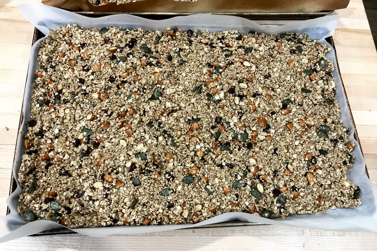homemade granola pressed in a baking sheet ready for the oven