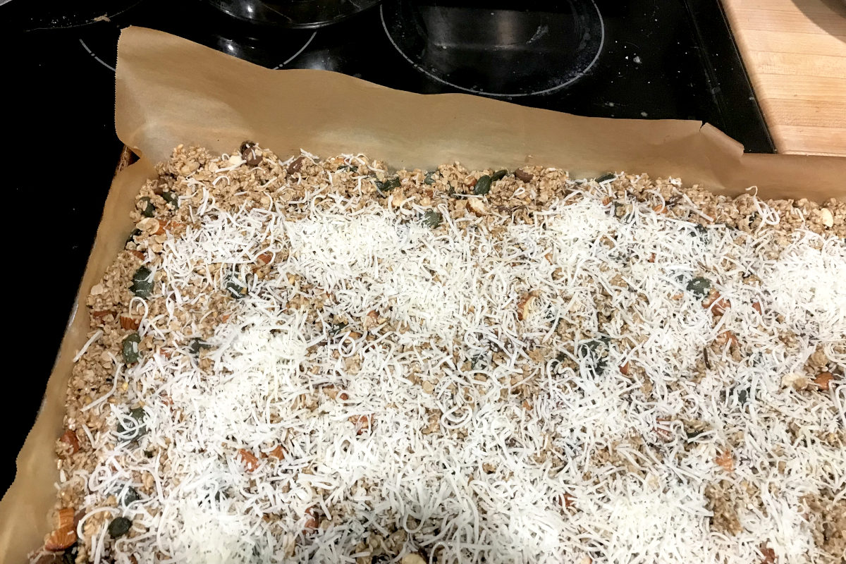 granola in pan sprinkles with coconut flakes