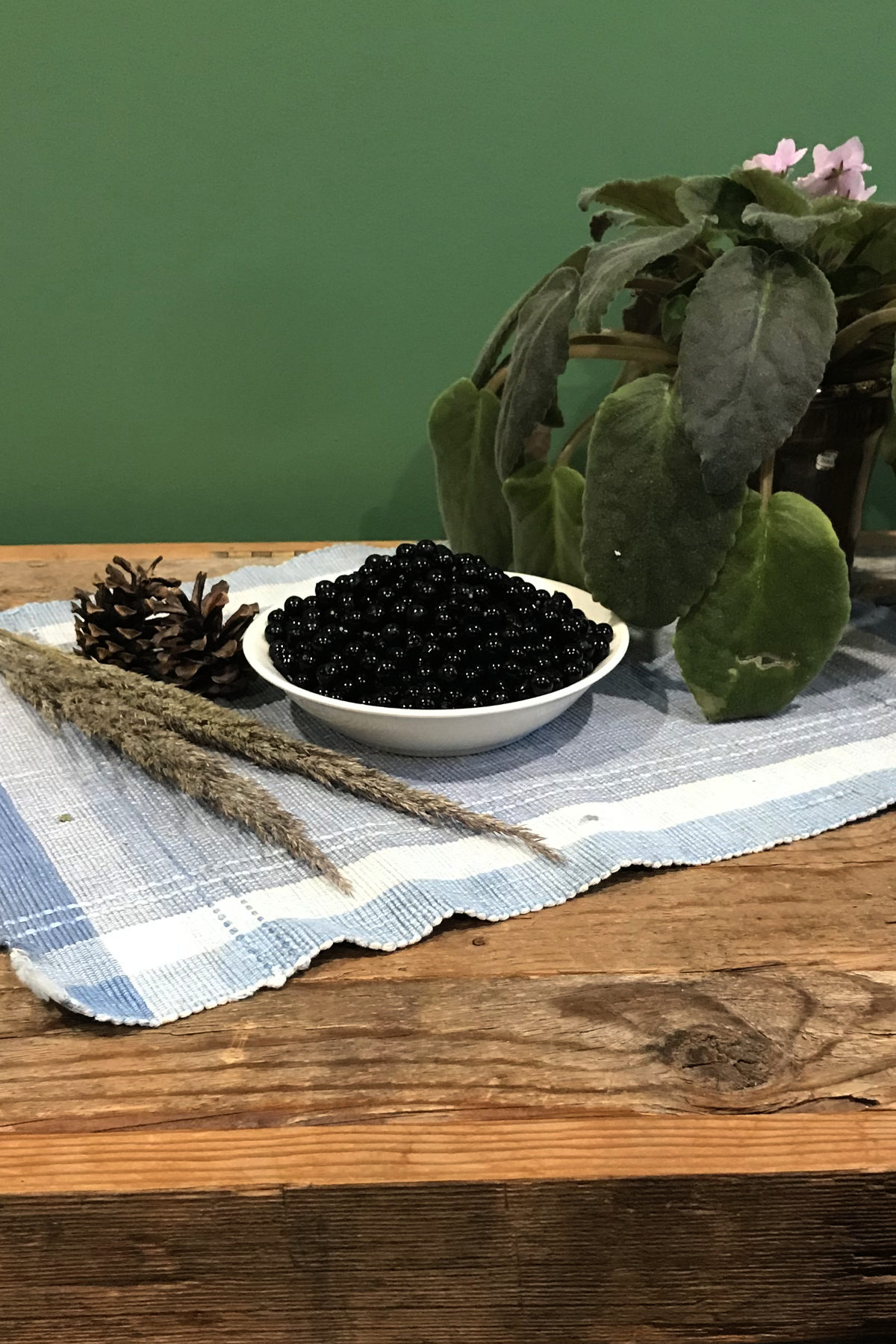 small bowl of wonderberries on place mat on weathered wood with greenery